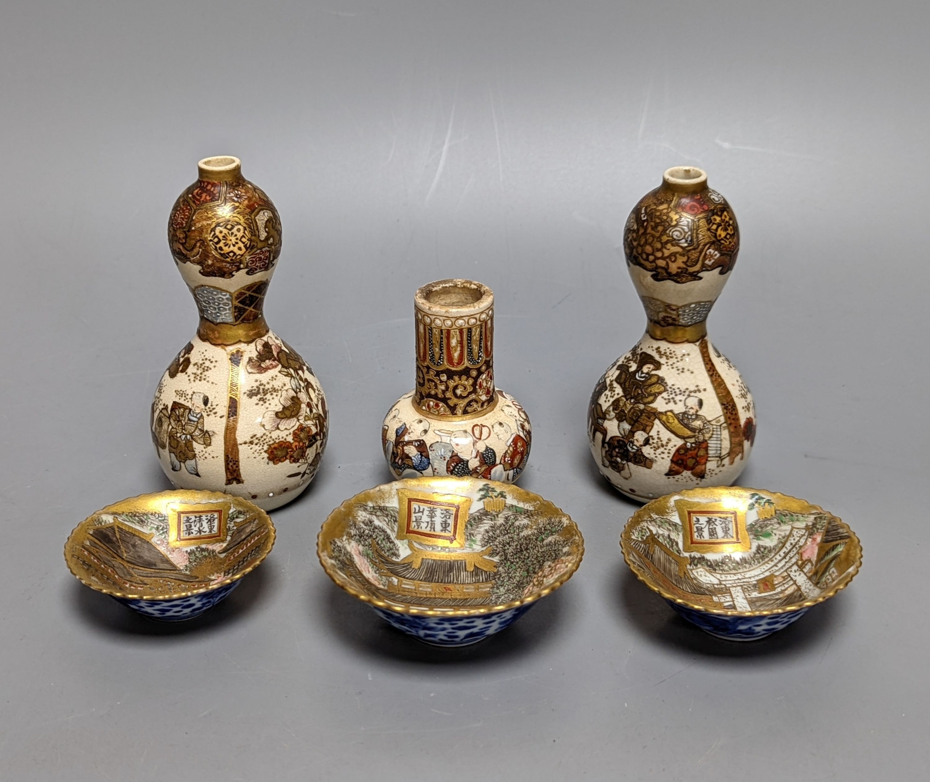 Three Japanese graduated porcelain miniature bowls, a pair of small Satsuma vases and another, pair of vases 12 cms high (6)